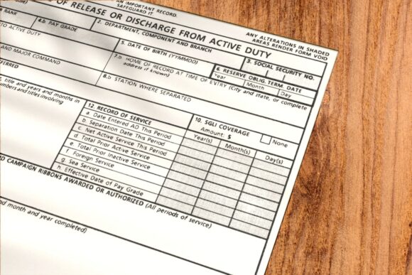 DD214 form laying on a wooden desk.