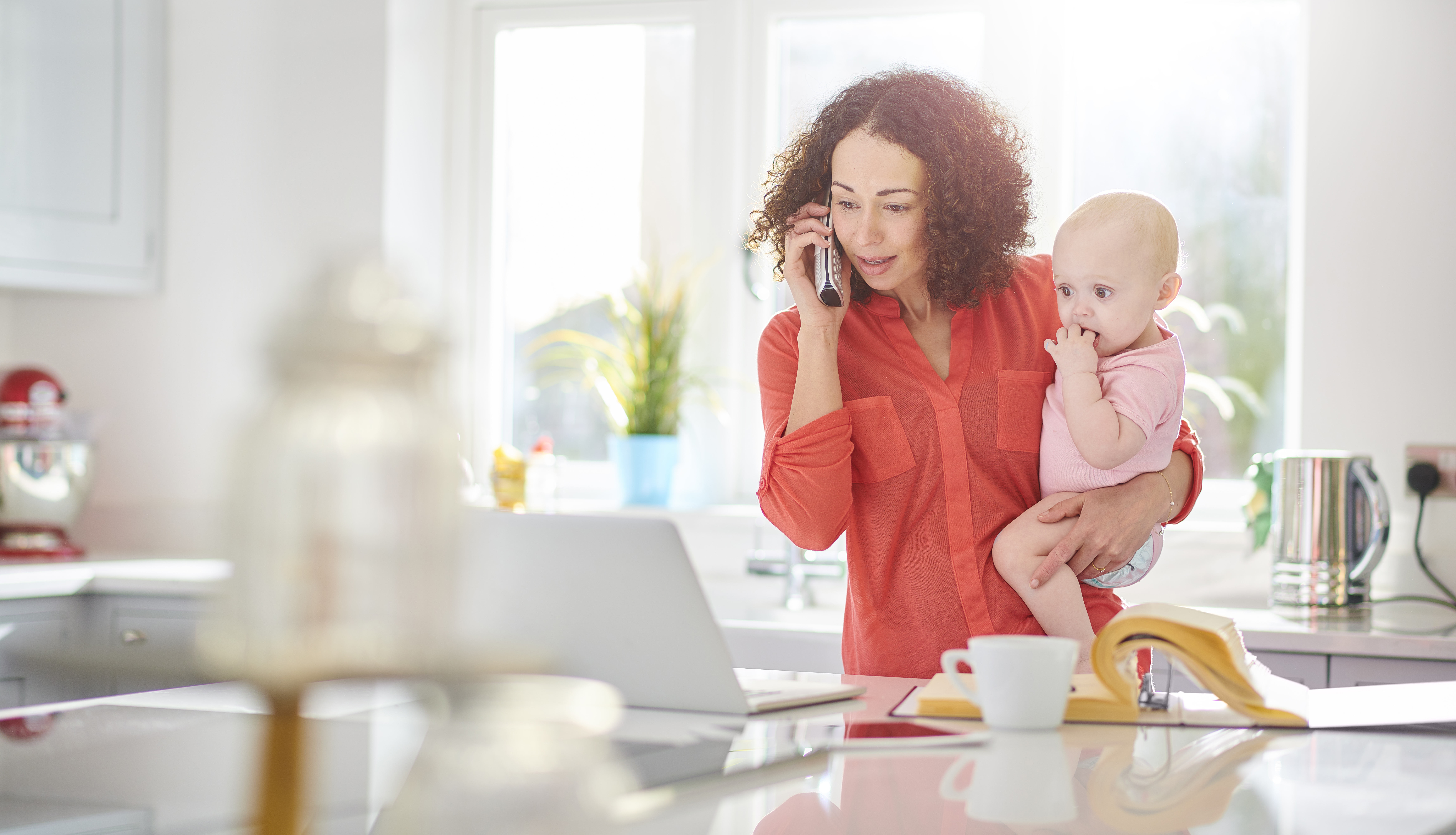 woman holds baby while speaking to financial advisor